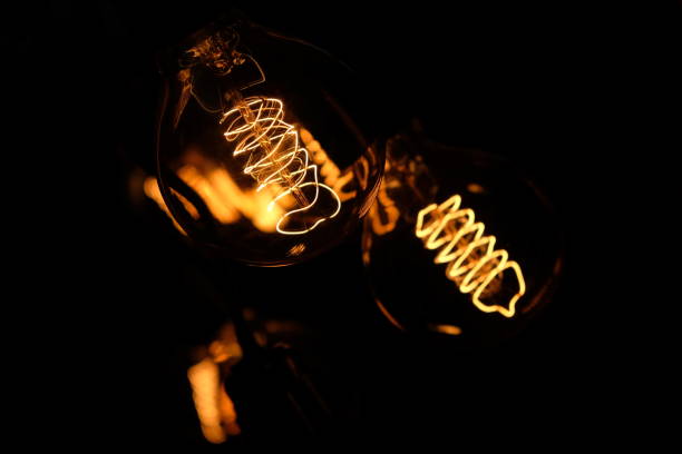 istock Classic Edisson bulbs backgound. Retro style bulbs. Vintage glowing light bulbs on a black background. 1288056403