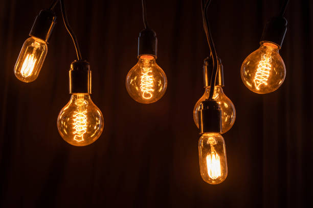 istock Classic Edisson bulbs backgound. Retro style bulbs. Vintage glowing light bulbs on a black background. 1288056445