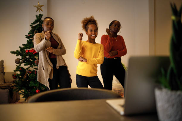 Tap tok Three female members of an African American family have lots of fun dancing Tik Tok routines on Christmas day. moving image stock pictures, royalty-free photos & images