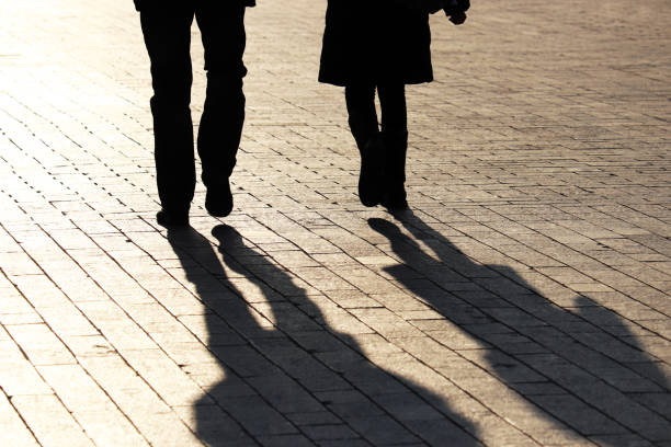 보행자 보도에 있는 두 사람의 거리, 실루엣, 그림자를 걷고 있는 커플 - shadow color image people sidewalk 뉴스 사진 이미지