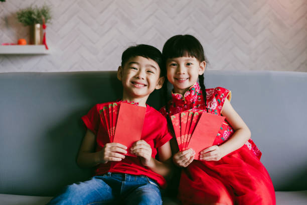 전통 드레싱과 빨간 봉투를 들고 사랑스러운 아시아 형제는 중국 새해를 축하합니다. - hong bao 뉴스 사진 이미지