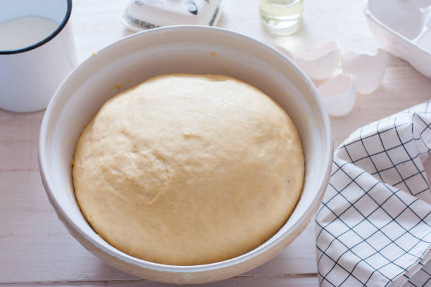 istock Freshly cooked yeast dough in ceramic bowl on white wooden table, selective focus 1288060918