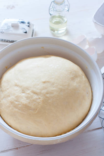 istock Freshly cooked yeast dough in ceramic bowl on white wooden table, selective focus 1288060946