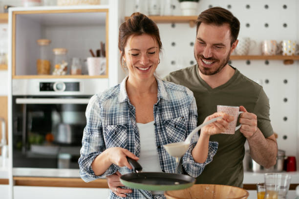 istock Husband and wife making pancakes at home. 1288063726
