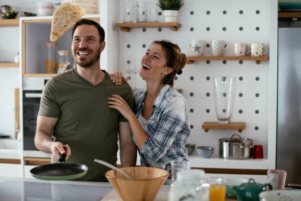 istock Husband and wife making pancakes at home. 1288064133