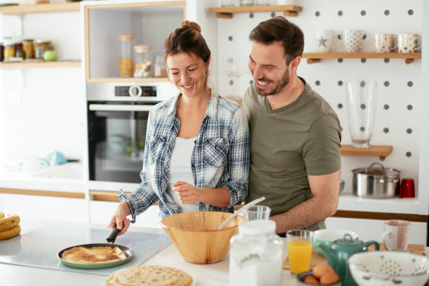 istock Husband and wife making pancakes at home. 1288064141