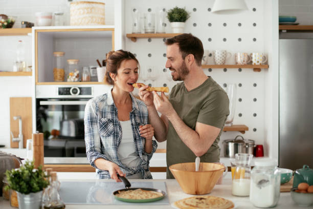 istock Husband and wife making pancakes at home. 1288064401