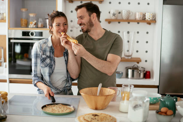 istock Husband and wife making pancakes at home. 1288065473