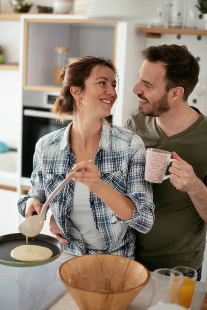 istock Husband and wife making pancakes at home. 1288065474