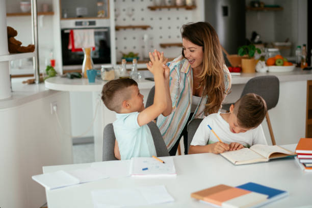 istock Mother helping her son with homework at home. 1288065919