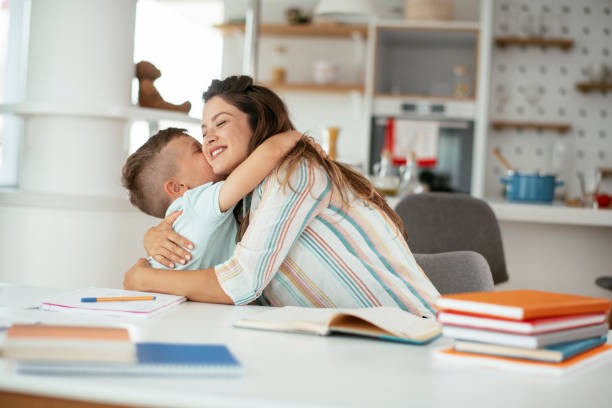 istock Mother helping her son with homework at home. 1288066154