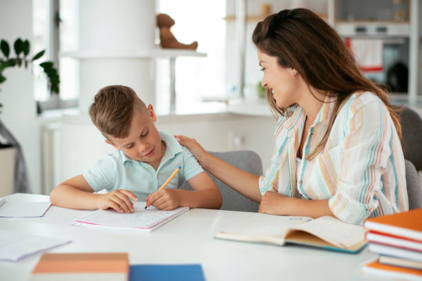 istock Mother helping her son with homework at home. 1288066158