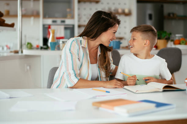 istock Mother helping her son with homework at home. 1288066519