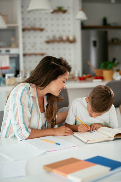 istock Mother helping her son with homework at home. 1288067116
