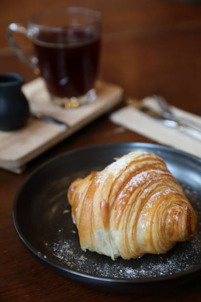 istock croissant with coffee close up on wood background 1288067237