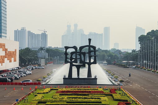 Jakarta, Indonesia - September 17, 2019: The front yard of the Indonesian People's Representative Council building (Gedung DPR), with a large garden, decoration, and Jakarta city building view