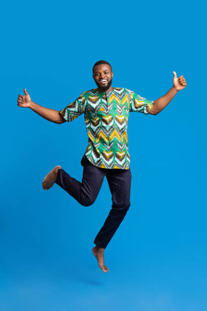 istock Positive black man jumping up over blue 1288067734