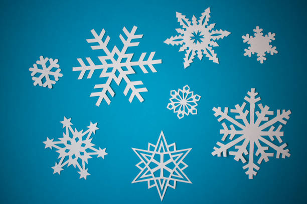 istock White paper snowflakes on light blue background 1288067922