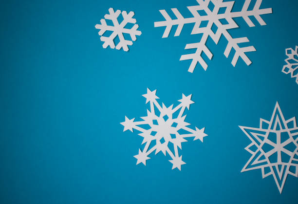 istock Paper cut snowflakes on light blue background 1288067938