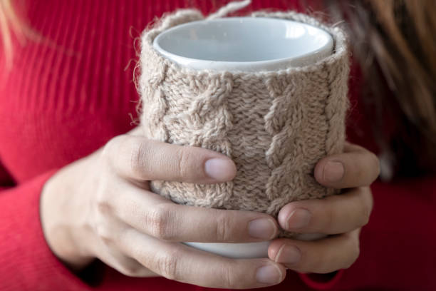 istock Girl is holding a cup with knitted cover. 1288069273