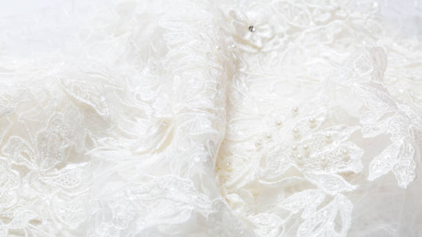 istock White luxurious guipure. Fabric for sewing a wedding dress. textile wedding background with beads. elegant wallpaper design 1288069365