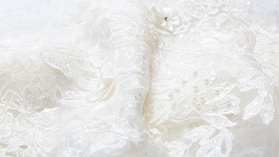 White luxurious guipure. Fabric for sewing a wedding dress. textile wedding background with beads. elegant wallpaper