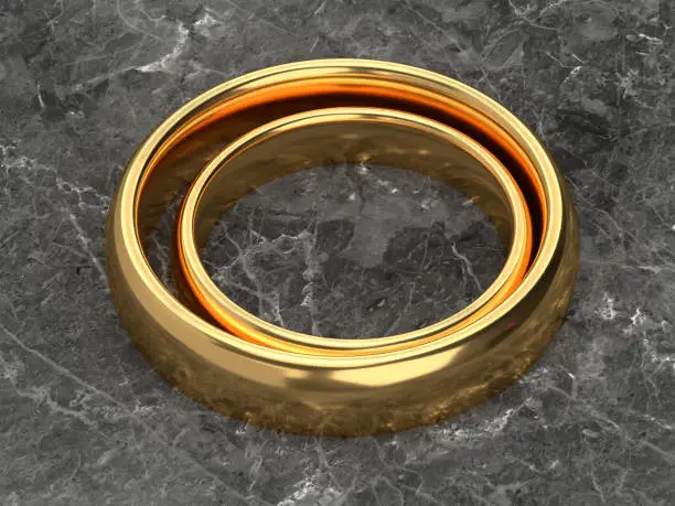 Two wedding gold rings lie next to each other on marble background. 3d rendering