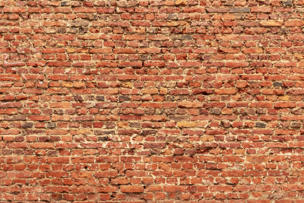istock Brick wall made of old crumbling red bricks 1288070768