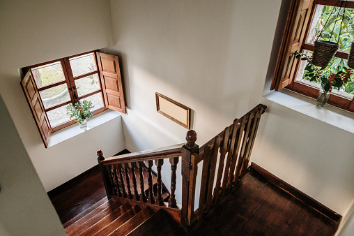 Portal of an urban residential house with veined white marble floors, light oak handrails, mailboxes and matching woodwork