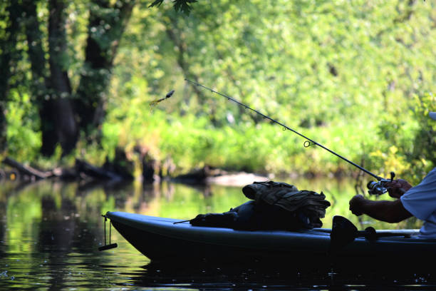 istock Man fishing on a kayak on a calm river 1288077275