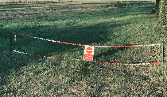 Access closed by a chain and a sign, that says in Italian \