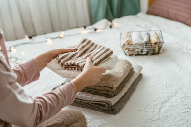 istock Woman folding stack of fresh laundry, organizing clothes and towels in boxes and baskets. 1288079732