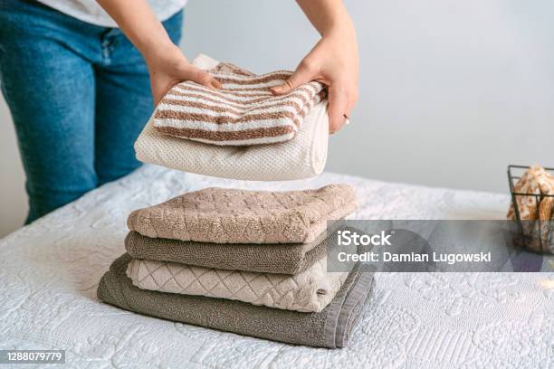 Woman Folding Stack Of Fresh Laundry And Towels Organizing Laundry In Boxes And Baskets Stock Photo - Download Image Now