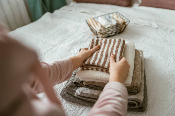istock Woman folding clothes in bedroom, organizing laundry in boxes and baskets. 1288079864