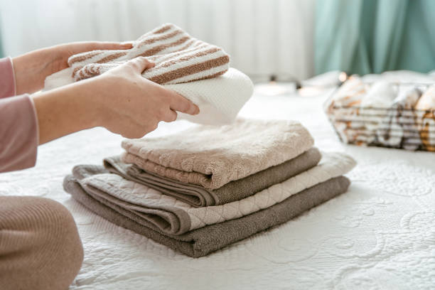 istock Woman folding clothes in bedroom, organizing laundry in boxes and baskets. 1288080017