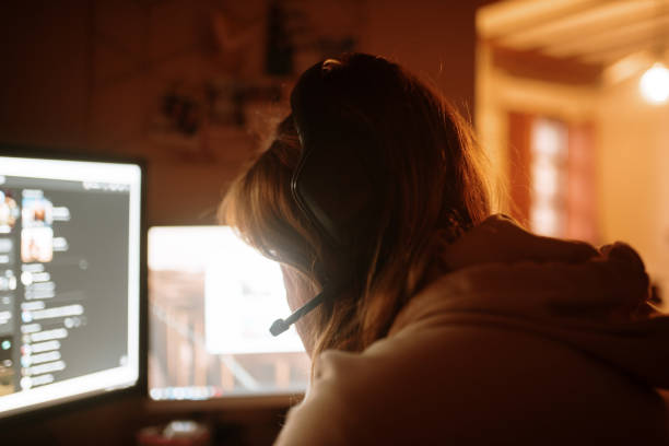 istock Young woman playing video games 1288083229