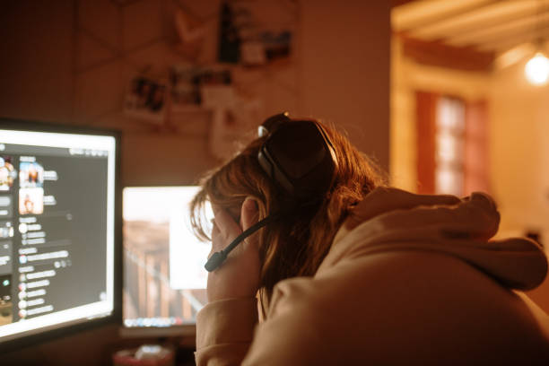 istock Young woman playing video games 1288083496