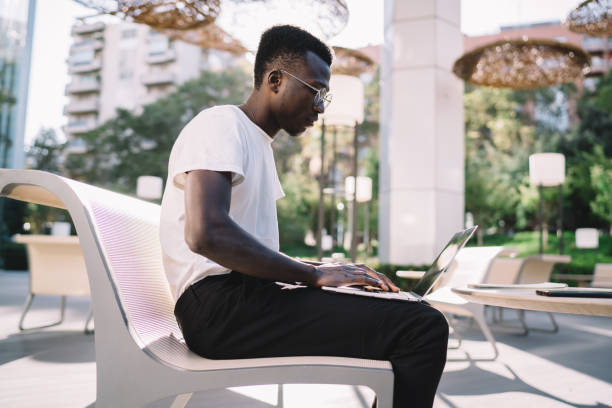 istock Concentrated man using laptop working in street 1288088065