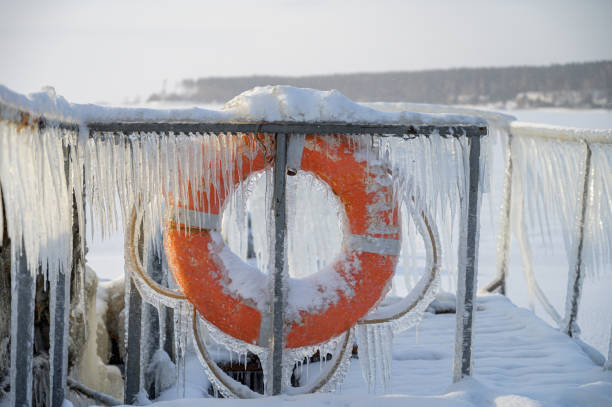 Lifebuoy in winter on the pier, covered with icicles.