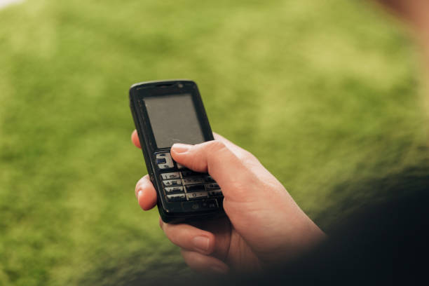 istock Girl Holds An Old Button Phone In Her Hand 1288088685