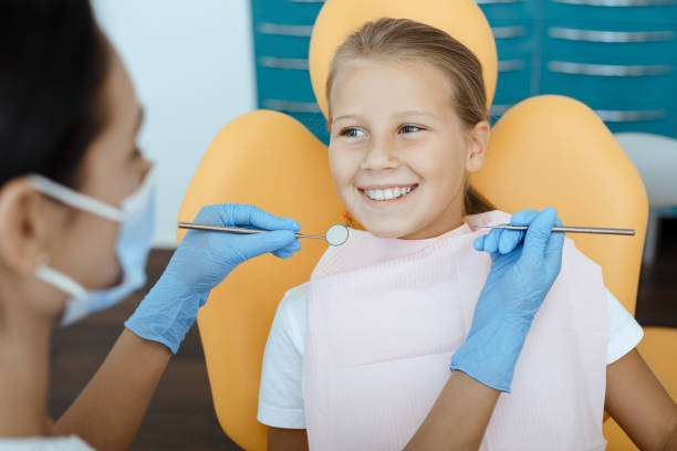 Routine check-ups, snow-white smile and pediatric dentistry Routine check-ups, snow-white smile and pediatric dentistry. Young female in protective mask and gloves examination happy little kid in medical chair, looking at doctor with tools in hand, cropped snow white and the seven dwarfs photos stock pictures, royalty-free photos & images