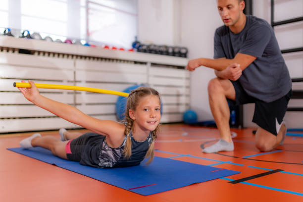 istock Back strengthening exercise for children with a bar 1288089549
