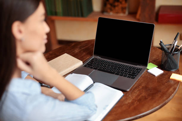 mujer sentada en el escritorio usando portátil con pantalla en blanco, maqueta - concentration teacher business copy space fotografías e imágenes de stock