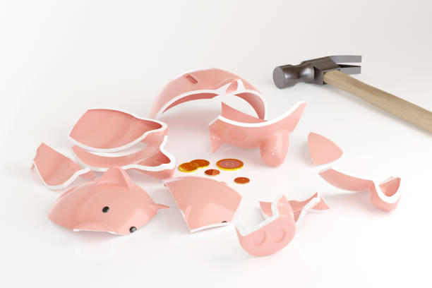 istock Broken piggy bank with some coins next to a hammer isolated on white background. 3d illustration.Broken piggy bank with some coins next to a hammer isolated on white background. Crisis concept. 3d illustration. 1288090837