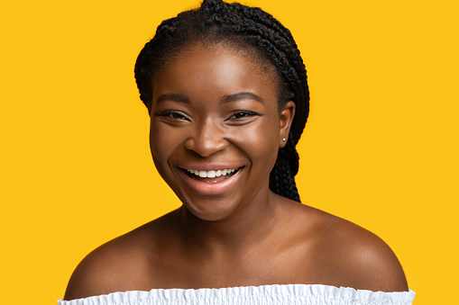 Happy Emotion. Closeup Of Cheerful Young Black Lady Laughing At Camera, Isolated Over Yellow Background, Joyful African American Woman With Braids Having Positive Mood, Sincerely Smiling, Free Space