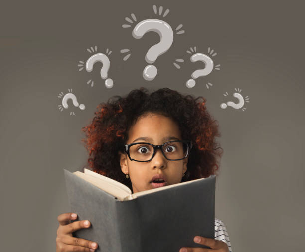 istock Puzzled black girl with book having trouble understanding school program, collage with question marks 1288092864