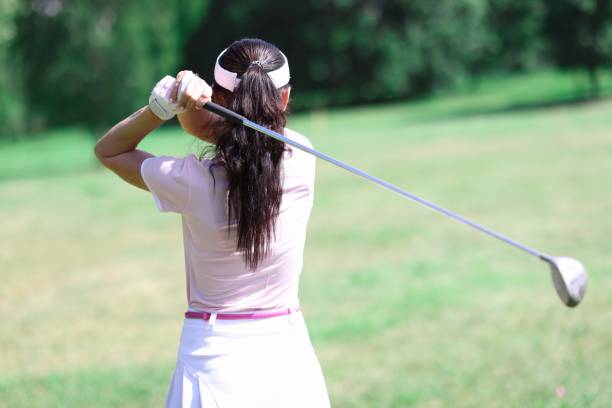 istock Woman in suit hold golf club behind her back. 1288094063