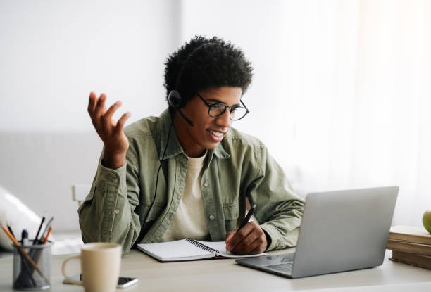 istock Online communication and web based learning. Positive black teenager speaking to his college tutor on laptop from home 1288095618