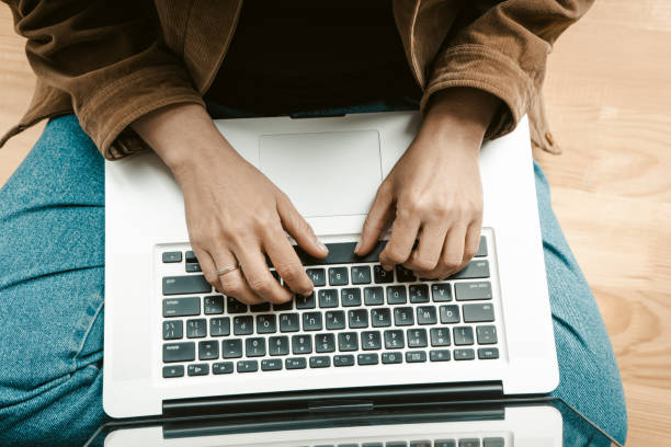 istock Close up. Top view. Woman hands working using laptop computer sitting on a windowsill. Beautiful aged woman runs her own business as a freelancer. Tinted photo 1288096694