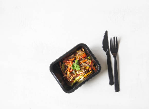 istock Black plastic container with vegetables stir fry and black appliances 1288098065